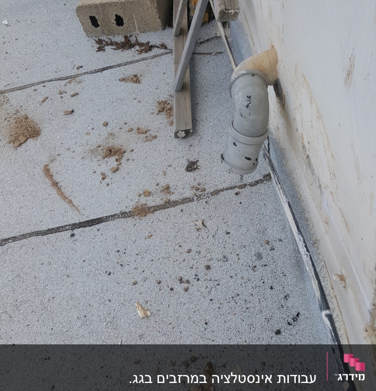 צינור מתכת על גג עם לכלוך וחול